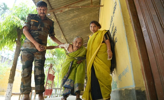 An elderly lady was seen going to a polling station to cast her vote with the help of volunteers and security personnel during the second phase of Lok Sabha Elections in Teliamura. PIC- Abhisek